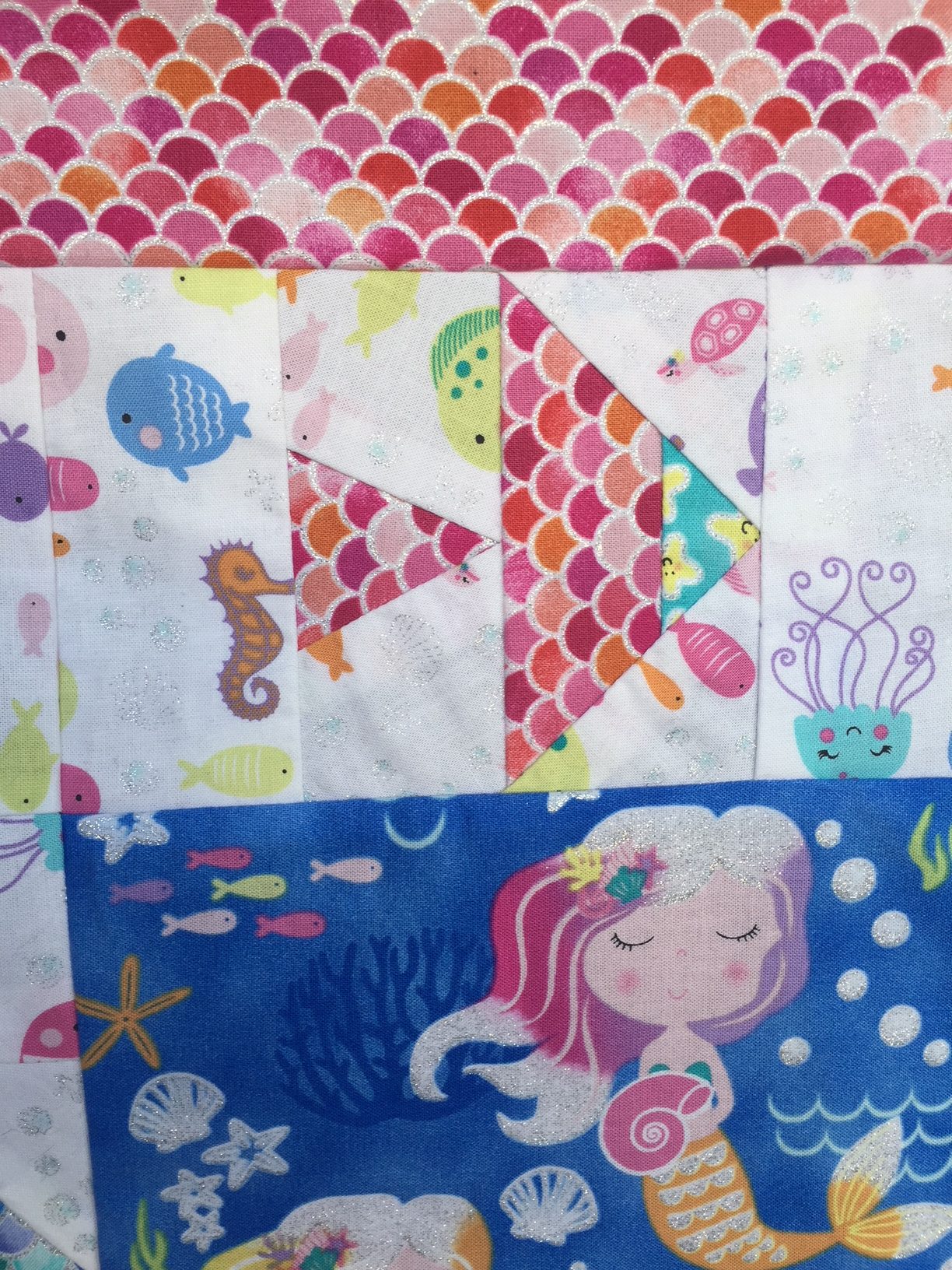 Mermaid Wishes quilt top con telas con purpurina de Northcott patchwork